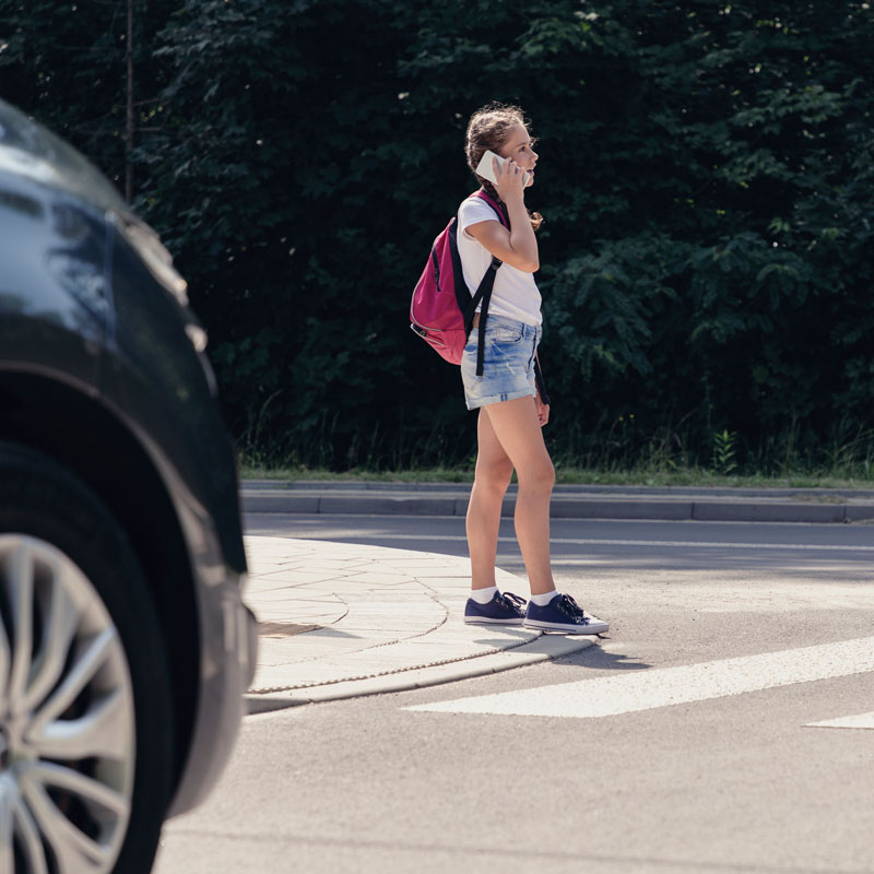 Child on phone stepping onto street